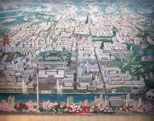 Artikelbild: Imposante Magistralen, Boulevards, gigantische Monumente und 
Plattenbauten. Pjöngjang in einer Wandmalerei im Eingangsbereich der 
Paektusan Academie of Architecture Pjöngjang.
Weiterlesen:>>> In Stein gemeißelte UnmöglichkeitDer sozialistische Totalitarismus und die Architektur - Von Ronald Pohl - Foto: Mak