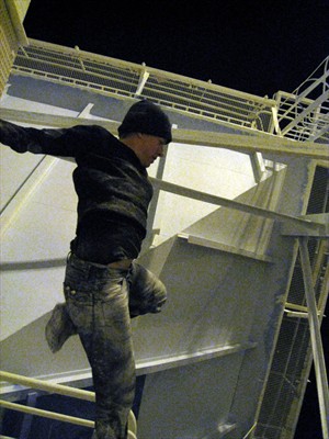 Artikelbild: Künstlerin und Kletterin Johanna Kirsch setzt den männlich besetzten 
Maschinen im Industriehafen Antwerpens ihren weiblichen Körper entgegen.
  - Foto: Johanna Kirsch 